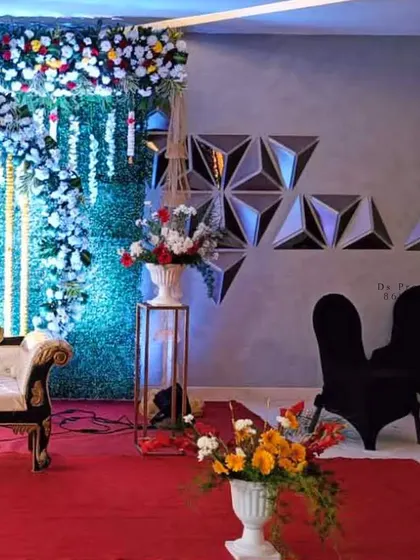 Another angle of the stage with a green wall backdrop and floral cascades.