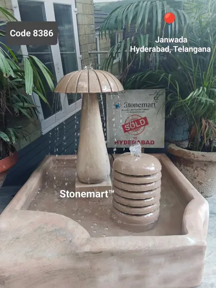 This unique mushroom-shaped fountain, sold to a client in Hyderabad, creates a soothing rainfall sound. It's carved from solid sandstone and is a whimsical yet elegant piece.
