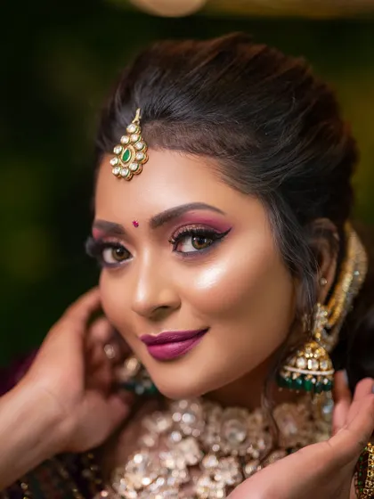 A close-up of a reception look with dramatic, winged eyeliner and a bold magenta lip, demonstrating a more glamorous style.