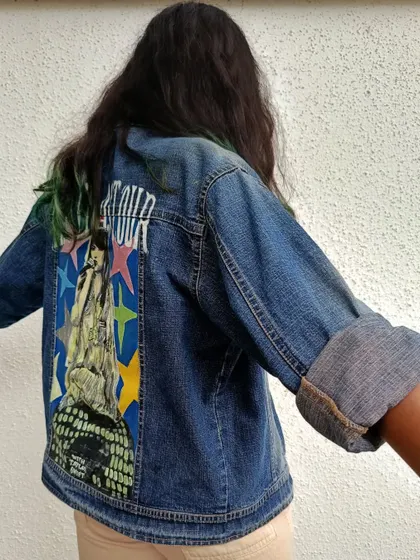 This side view of the Taylor Swift jacket shows how the artwork sits on the denim and how the rolled-up sleeves give it a casual, cool look.