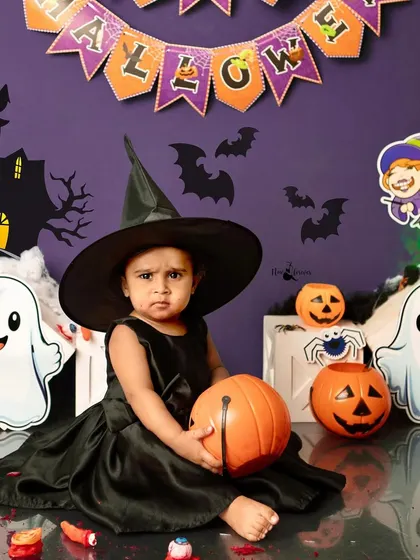 A slightly grumpy but adorable little witch holding her pumpkin. We capture all the expressions, as they are all part of the memory.