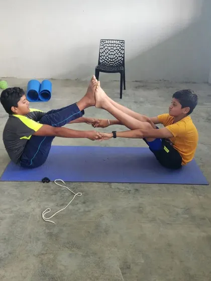 These two campers show great concentration and teamwork in their partner boat pose.