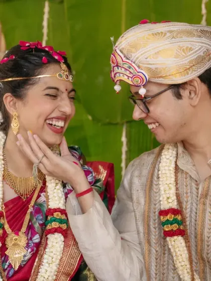 A candid moment of laughter and love between the bride and groom during their traditional wedding ceremony.