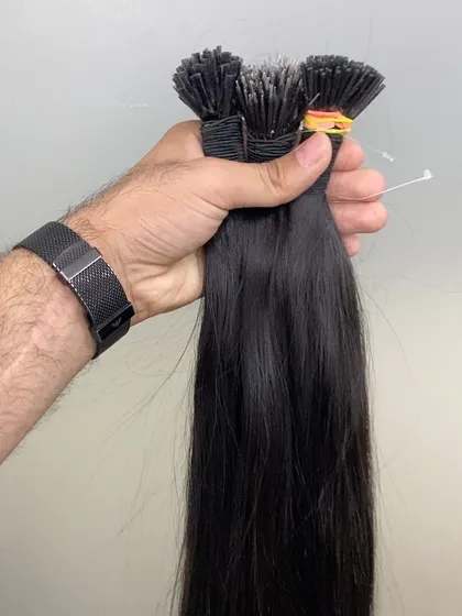 A handful of our natural black I-Tip extensions, showing the density and quality of the hair. We supply premium extensions for professional results.