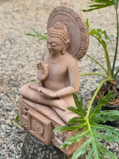 Our pink sandstone Buddha in the teaching posture, placed in a garden setting, embodying peace and serenity.