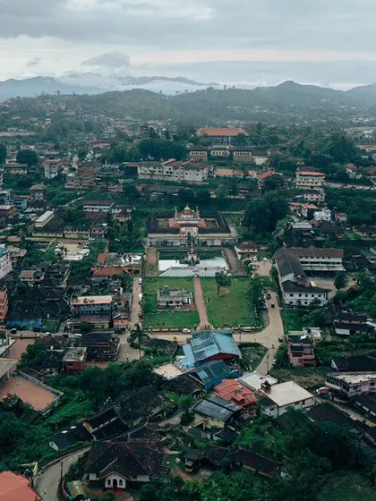 A wide aerial photograph of the Omkareshwara Temple in the heart of Madikeri, Coorg. This image shows the temple's unique Indo-Saracenic architecture and its placement within the town.