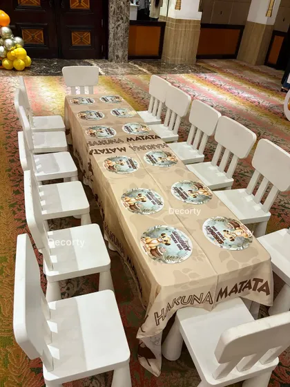 Child-sized tables and chairs set up for the little guests at the Lion King party, complete with themed tablecloths.