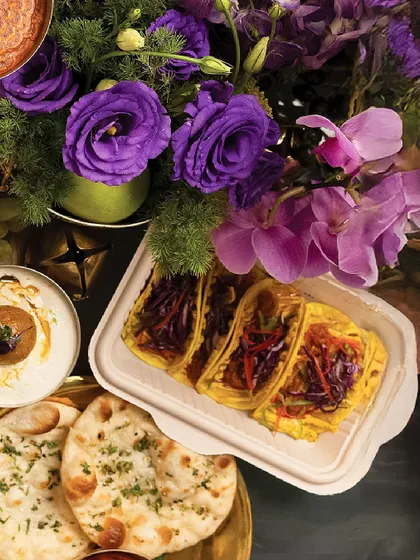 An assortment of dishes from our Diwali menu, including savory tacos and fresh naan, showcasing the variety within a single feast.