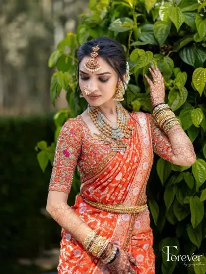 A close-up of the bride's profile, showing the delicate details of her makeup and the beautiful texture of her embroidered blouse.
