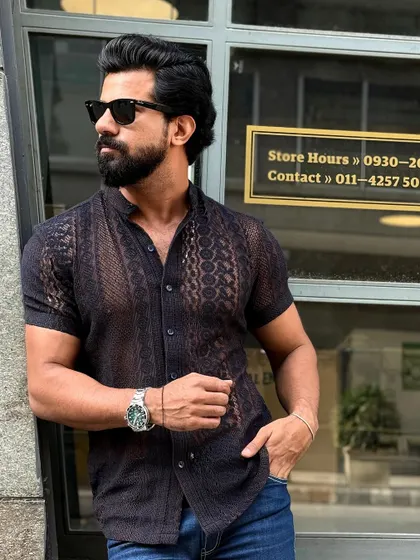 Another angle of the black knitted mesh shirt, highlighting its unique texture and modern design.