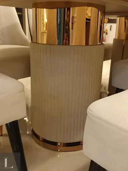 A close-up detail of the dining table base, featuring a combination of fluted upholstery and a rose gold metallic finish. This highlights the bespoke craftsmanship that goes into my furniture designs.