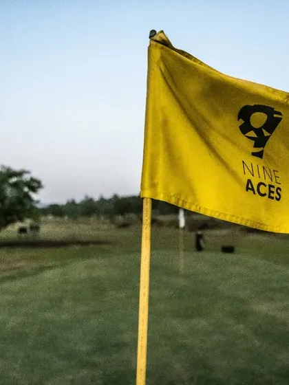 The yellow '9 Aces' flag stands out against the green, a beacon for players. It represents the attention to detail and quality you can expect throughout our course.