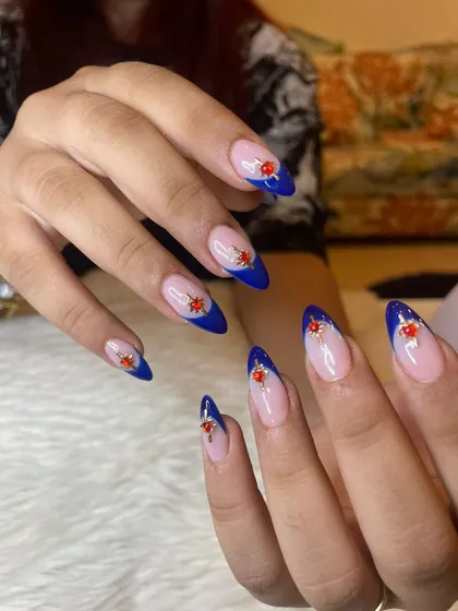 Into the blues right now with these royal blue French tips, accented with intricate red and gold gem clusters.