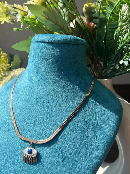 A trendy evil eye pendant on a gold-plated snake chain, a popular accessory choice.