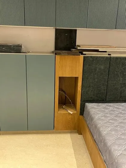 A work-in-progress shot of a bedroom project, showing the built-in cabinets and headboard before the final finishing touches. This reveals the underlying structure and precision required for integrated furniture.