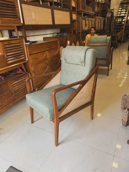 Front view of the sage green lounge chair with teak frame.