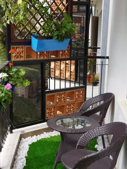 This view highlights the seating nook, perfect for enjoying a morning coffee surrounded by greenery. The terracotta jali block wall adds a traditional touch and extra privacy.