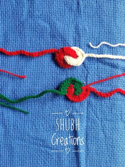 Two minimalist crochet rakhis in red and green, featuring a simple spiral design.