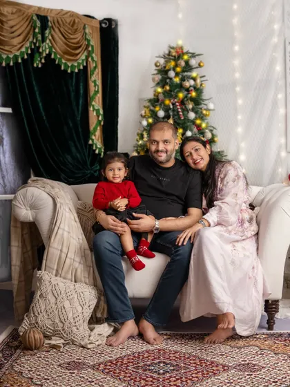 A classic family pose on the couch, everyone smiling, creating a perfect memory to cherish for years to come.