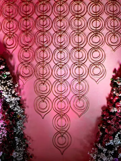 A cascading wall installation made of interlocking golden rings, another artistic representation of eternal connection within our 'Anant' theme.
