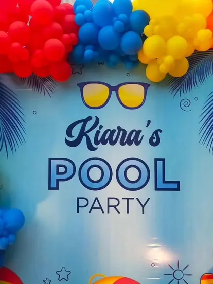 The "Kiara's Pool Party" backdrop, framed perfectly by a colorful balloon garland, ready for photos.