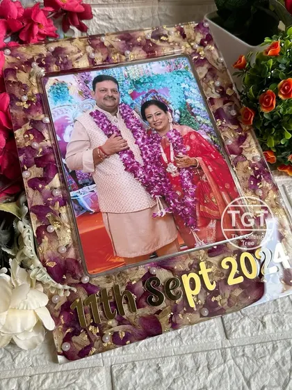 The frame features a dedicated space for the photo, with the preserved flowers creating a beautiful, textured border. The anniversary date is highlighted in bold, golden text.