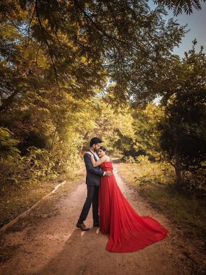 For this pre-wedding portrait, I wanted to create a sense of fairytale romance. The flowing red gown stands out against the lush, sun-dappled forest path, creating a wide, cinematic frame that feels like a scene from a movie.