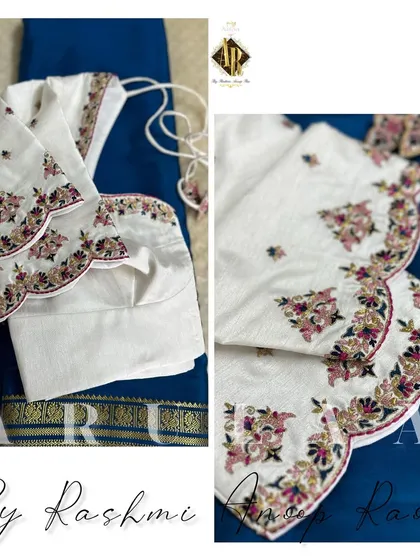 A pristine white blouse with multi-color floral embroidery along the scalloped sleeve edges. This is a perfect blouse to pair with a dark-colored saree for a striking contrast.