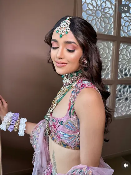 A soft and romantic half-updo with curls, adorned with tiny flowers. This look was created for a masterclass demonstration in Pune.