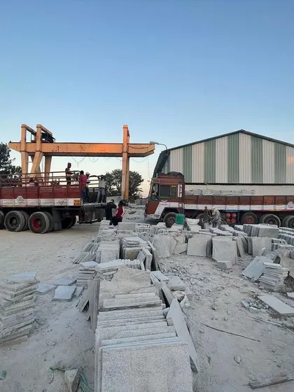 A view of my stone yard, with trucks being loaded with Bangalore stone slabs for delivery.