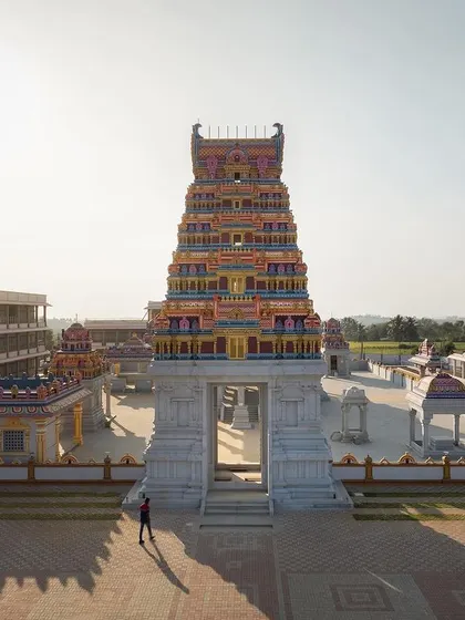 The main Gopuram stands as a monumental entrance to the spiritual heart of the complex. The scale is designed to evoke a sense of awe and reverence, marking the beginning of the 'adhyatmika gola' or spiritual realm for visitors.