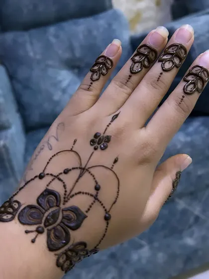 Simple, elegant, and beautiful. This design features a butterfly motif on the wrist with delicate beaded chains connecting to floral patterns on the fingers.
