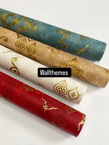 A collection of four damask-style wallpaper rolls in red, white, beige, and teal, all with gold accents.