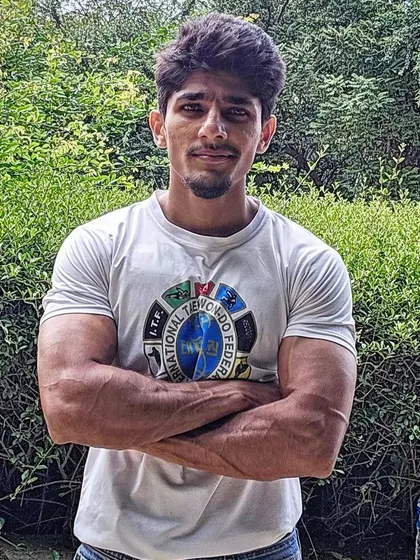A portrait of me in an ITF Taekwondo t-shirt, showing the arm and shoulder strength developed through consistent training.