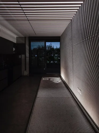 A duplicate of ID 71, this image shows the dramatic effect of the custom lighting design in one of our studio's corridors. The interplay of light and perforation creates a dynamic and ever-changing surface pattern.