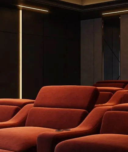A close-up rendering of the luxurious red recliners, showing the texture of the fabric and the integrated cup holders.