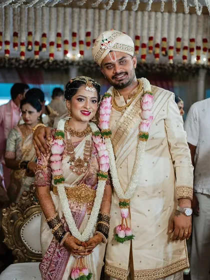 A classic wedding portrait. The bride's soft pink and white saree is complemented by the groom's custom cream sherwani, showcasing how I coordinate colors and embroidery for the perfect pair.