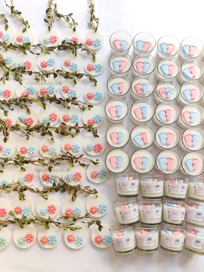 The full set of components for a large baby shower order, including baby feet candles and floral wax sachets.