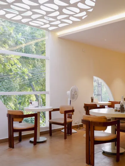 This image from a cafe project shows how we use natural light and architectural details, like the custom-patterned ceiling, to create a bright and airy atmosphere.