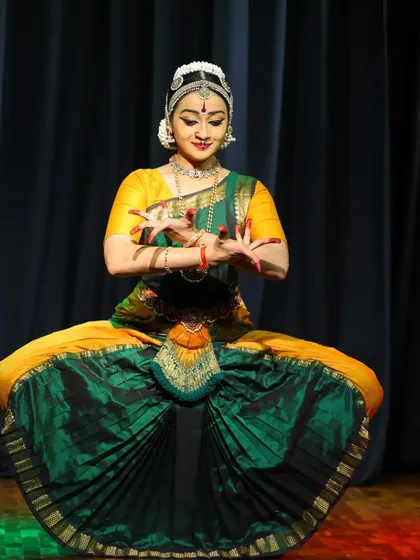 A classic seated pose from the Ninada Nruthyotsava, with the fan of the costume beautifully spread.