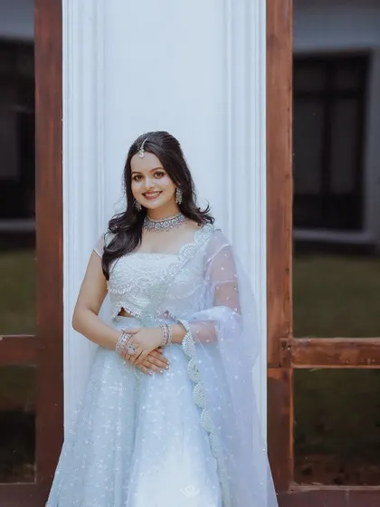 A full-length portrait of a woman in a beautiful light blue lehenga, perfect for an evening celebration.