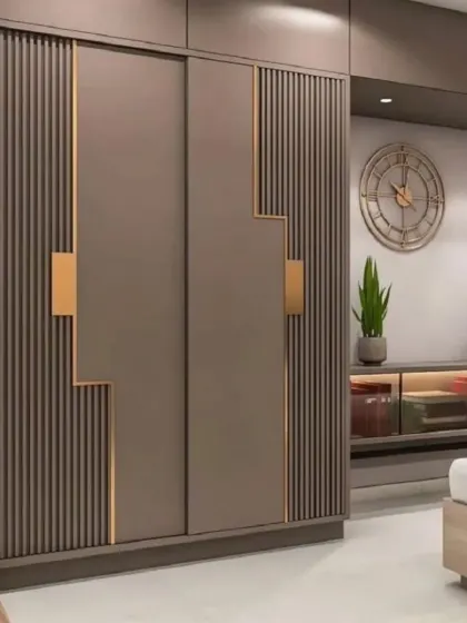 This wardrobe design combines function with artistry. The sliding doors feature a unique geometric pattern with fluted textures and metallic gold accents, turning a storage unit into a statement piece.