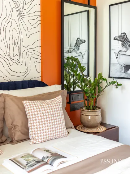 A close-up of the bedside styling, featuring a fun black and white photo of a zebra in a bathtub. A potted plant adds a touch of green, and the houndstooth pillow brings a classic pattern into the mix.