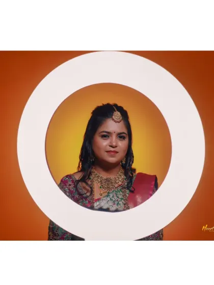 A creative bridal portrait using a ring light against a warm orange background.