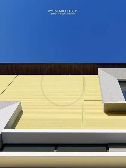 An upward-looking detail shot of the Anbalagan residence. This angle emphasizes the clean lines and geometric interplay of the cantilevered window boxes against the sky, a key feature of this compact house design.