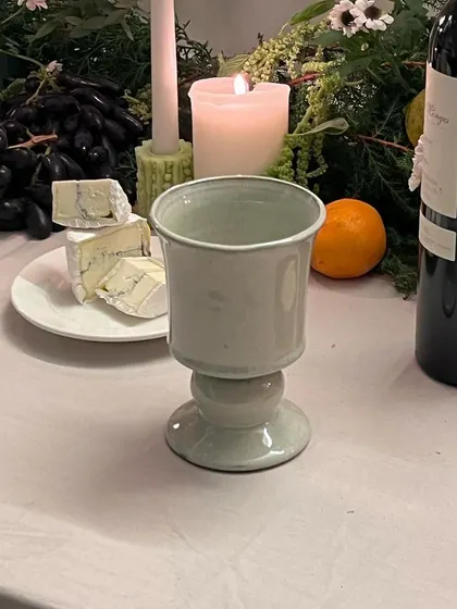 The 'Heccu' goblet, with its regal chalice design, sits on a candlelit table. Each piece bears the hallmark of fine traditions and meticulous craftsmanship.