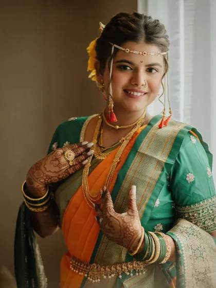 Enhancing natural elegance with a touch of artistry. This beautiful Maharashtrian bride glows in her traditional orange and green saree, with makeup that feels fresh and timeless.