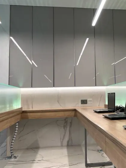 A detail of the workspace in the advocate's office, showcasing the clean lines of the high-gloss cabinetry, marble backsplash, and integrated lighting. The design is both highly functional and aesthetically pleasing.