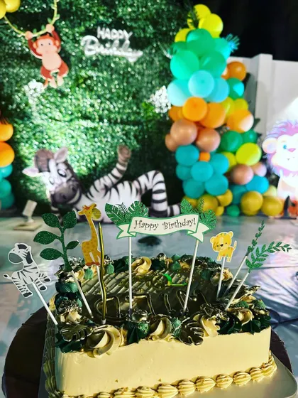 A close-up of the jungle-themed cake, showing the fun toppers and decorations.