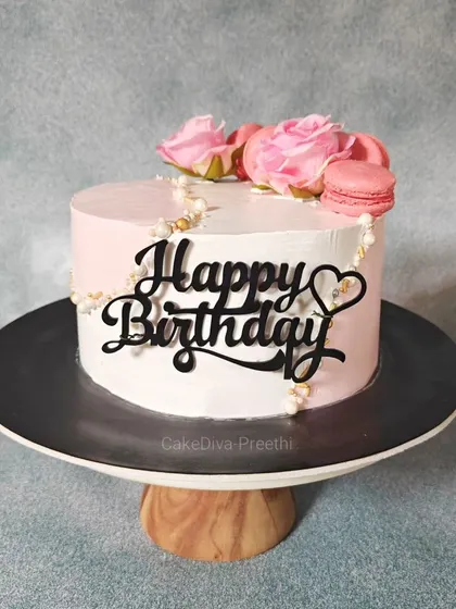 A pretty-in-pink fault line cake for a birthday. This design is decorated with fresh pink roses and macarons, offering an elegant look without any fondant.